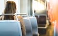 Back view of young woman sitting in public transportation