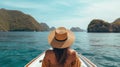 Back view of the young woman in straw hat relaxing on the boat and looking forward into lagoon. Travelling tour in Asia: El Nido, Royalty Free Stock Photo