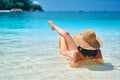 Back view of young woman in straw hat and white bikini relax in turquoise sea Royalty Free Stock Photo