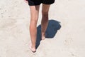 Back view young woman tanned legs and feet walking on sand beach ocean on sunset Royalty Free Stock Photo