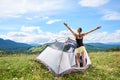 Woman tourist hiking in mountain trail, enjoying summer sunny morning in mountains near tent Royalty Free Stock Photo