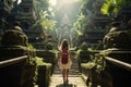 Back view of young woman traveler with backpack walking in balinese temple, Tourist woman with backpack at vacation walking