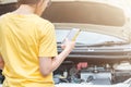 Back view of young woman trying to call someone to help her after her car breakdown on the road. Royalty Free Stock Photo