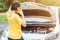 Back view of young woman trying to call someone to help her after her car breakdown on the road. Royalty Free Stock Photo