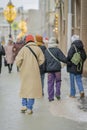 Back view of young woman walking at city street in winter. Modern city Royalty Free Stock Photo