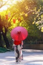 Back view of a young woman wearing a Japanese Yukata and holding a paper umbrella