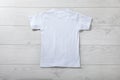 Back views on boys t-shirts on white wooden desk background. Mockup for design closeup Royalty Free Stock Photo