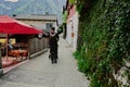 Back of walking father with baby carriage walking in Hallstatt, Austria