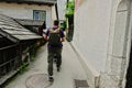 Back of walking father with baby carriage walking in Hallstatt, Austria