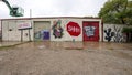 Back wall of a building with multiple graffiti style murals in West Dallas, Texas.