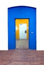 Back white door framed by a blue entrance