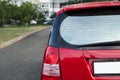 Back window of a red car parked on the street, rear view.