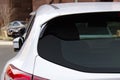 Back window of a white car parked on the street, rear view. Mock-up for sticker or decals Royalty Free Stock Photo