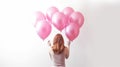back of woman with bunch of pink helium balloons on white background Royalty Free Stock Photo