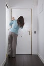 Back woman looking at peephole