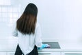 The back of woman in protective gloves blue wiping dust using spray and cloth while cleaning her kitchen. People, housework Royalty Free Stock Photo