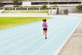Back, woman and running on race track for athletics, fitness or competition training in stadium. Runner, exercise and Royalty Free Stock Photo