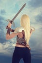 Back of woman warrior holding a sword Royalty Free Stock Photo