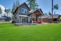 Back yard with fire pit and red chairs near newly bild luxury real estate home with forest biew and green grass Royalty Free Stock Photo