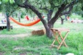 Back yard with hammock and wooden table for relaxing. Terrace, apple garden in summer, wooden table with haystack. wooden table on