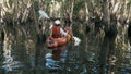 Back young adult woman paddling kayaking canoe on a lake on summer day Royalty Free Stock Photo