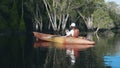 Back young adult woman paddling kayaking canoe on a lake on summer day Royalty Free Stock Photo