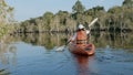 Back young adult woman paddling kayaking canoe on a lake on summer day Royalty Free Stock Photo