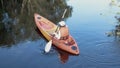 Back young adult woman paddling kayaking canoe on a lake on summer day Royalty Free Stock Photo