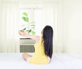 Back of young asian woman wearing yellow undershirt exercising yoga while sitting on a white bed by the window with a thin curtain Royalty Free Stock Photo