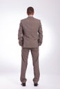 Back of a young business man with both hands in pockets Royalty Free Stock Photo