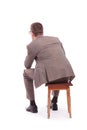 Back of a young business man sitting on a chair