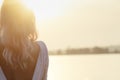 Back of a young girl enjoying sunrise by the river, a woman with naked back on the nature relaxing