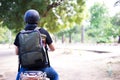 Back of Young happy and handsome male motorcyclist in helmet riding on motorbike on country road. Royalty Free Stock Photo