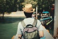 Back of young male solo traveler walking on path towards tropical island in Thailand