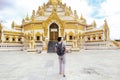 Back of young man backpacker walking towards Burmese temple name