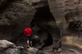 Lonely adventurer hiking on flowing shapes wall caves
