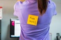 Back of young woman office with a yellow sticky note attached with the text Free Hug. happy april fools day concept Royalty Free Stock Photo