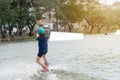 Back of the young woman wake boarding on a lake with cable in Bangkok Thailand. Concept sport and leisure activities