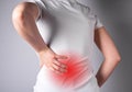 Backache. Woman suffering from lower back pain with red spot closeup. Muscle spasm, sprains, strains, inflammation Royalty Free Stock Photo