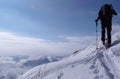 Backcountry skier hikes and climbs to a remote mountain peak in Switzerland on a beautiful winter day Royalty Free Stock Photo