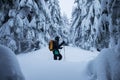 Backcountry skier pushing through the fog on a snowy slope. Ski touring in harsh winter conditions. Ski tourer sporting