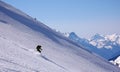 Backcountry skier skiing really fast down an untouched mountain side with loads of fresh powder snow Royalty Free Stock Photo