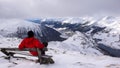 Backcountry skier takes a break and sit on a summit bench and enjoys the view of Davos in winter Royalty Free Stock Photo