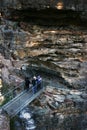 Tourists hiking across trail bridge of Grand Stairway along steep shear rock cliff at Three Sister in Blue Mountains National Park Royalty Free Stock Photo