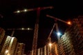 Backdrop for industrial style. Building construction site with cranes and light flare at night time background Royalty Free Stock Photo