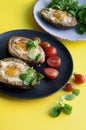 Backed avocado with egg and tomatoes on green background Royalty Free Stock Photo