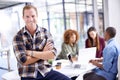 Backed by a team of bold and talented creatives. Portrait of a young designer standing in an office with his colleagues