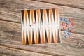 A backgammon board with red and blue checkers and small dices on a wooden table Royalty Free Stock Photo