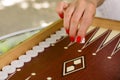 Backgammon bone square white dice for gambling with blurred background. woman with red nails is playing backgammon Royalty Free Stock Photo