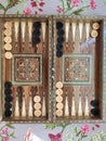 Wooden backgammon board game of pearl inlaid on brown background.